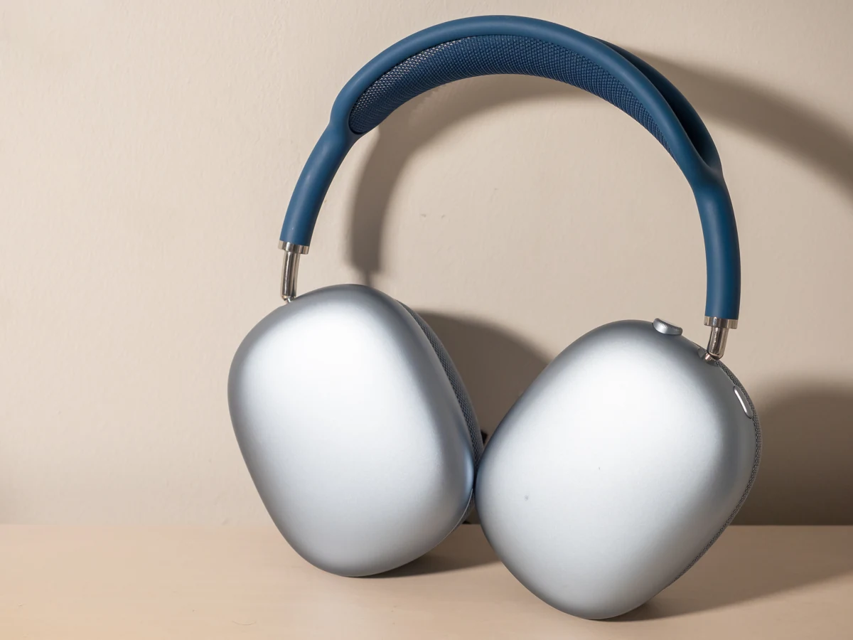 Exact silver and blue Apple AirPods Max headphones photographed against a wall