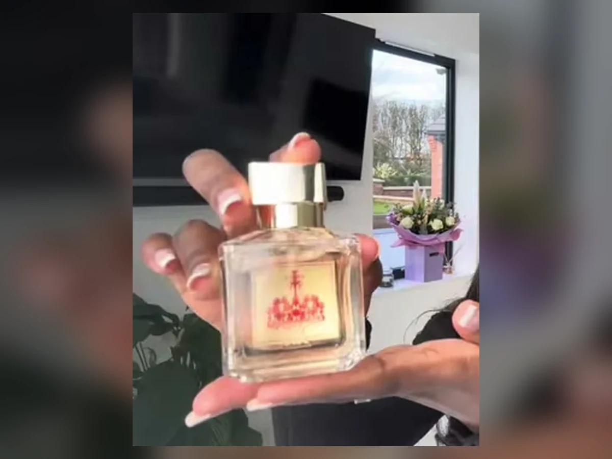 Hand holding the exact Baccarat Rouge 540 eau de parfum bottle