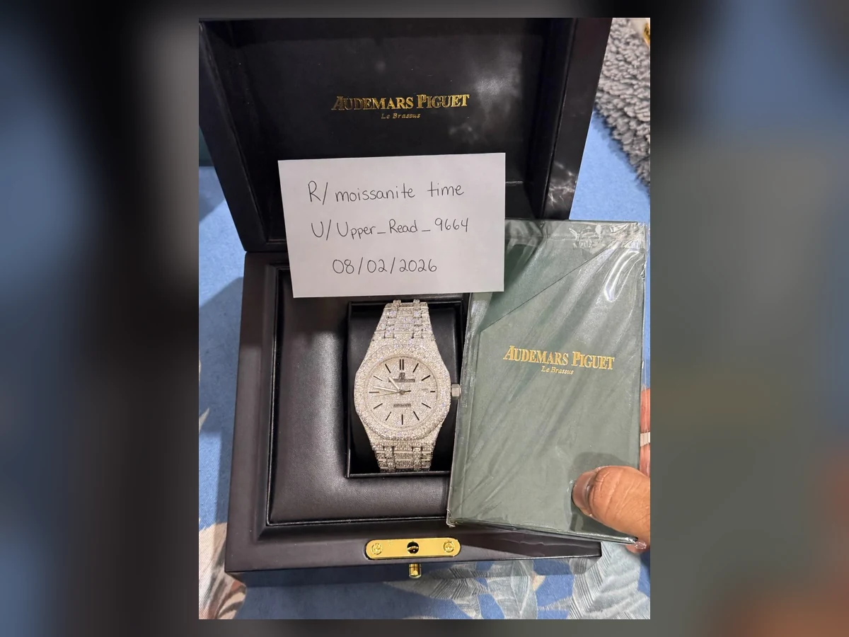 Hand holding an exact fully iced AP-style moissanite watch