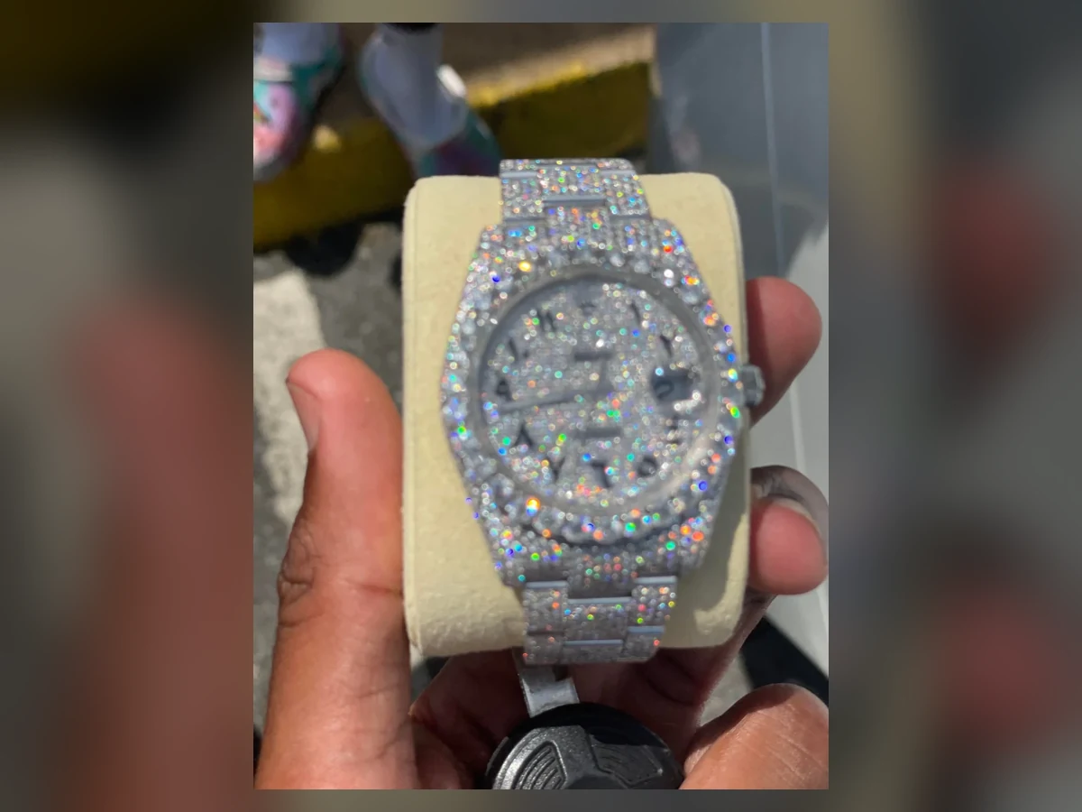 Hand holding an exact fully iced Rolex Datejust-style moissanite watch