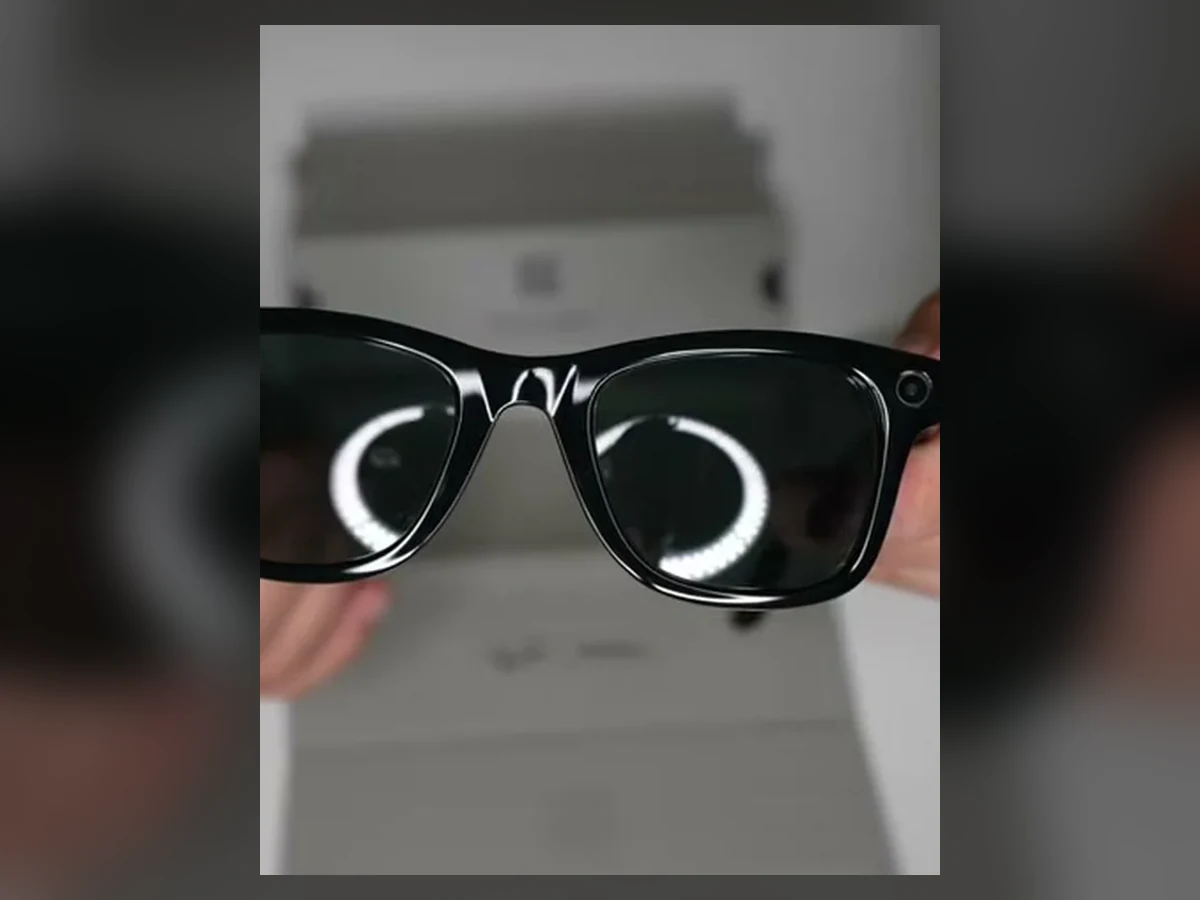 Hands holding the exact Ray-Ban Meta Gen 2 Wayfarer glasses above their packaging